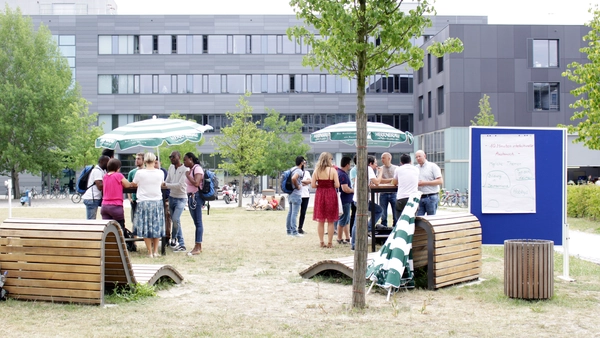 Menschen auf der Campus Wiese im Gespräch