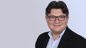 Prof. Dr. Cristian R. Loza Adaui vor einem grauen Hintergrund