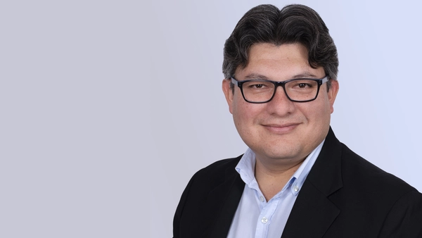 Prof. Dr. Cristian R. Loza Adaui vor einem grauen Hintergrund