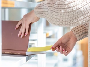 Frauenhände schlagen ein Buch auf