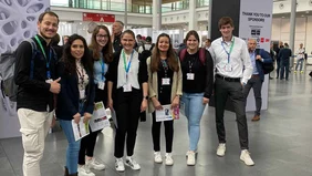 A group of seven students in an exhibition hall.