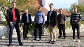 Gruppe von Menschen vor Schloss