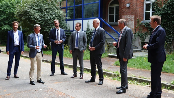 Landrat Peter von der Grün, Staatsminister Bernd Sibler, Thomas Sendtner (Staatlichen Bauamts Ingolstadt), MdL Matthias Enghuber, Prof. Dr. Walter Schober (Präsident der THI), Oberbürgermeister Dr. Bernhard Gmehling, MdB Dr. Reinhard Brandl in front of building 6 in Neuburg, which will first be renovated and moved into in WS 21/22.Quelle: THI