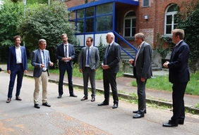 Landrat Peter von der Grün, Staatsminister Bernd Sibler, Thomas Sendtner (Staatliches Bauamt Ingolstadt), MdL Matthias Enghuber, Prof. Dr. Walter Schober (Präsident der THI), Oberbürgermeister Dr. Bernhard Gmehling, MdB Dr. Reinhard Brandl vor dem Gebäude 6 in Neuburg, das zuerst saniert und im WS 21/22 bezogen werden wird. Quelle: THI