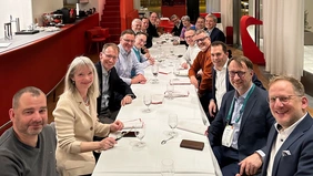 A group of people sitting at a long table in a restaurant.