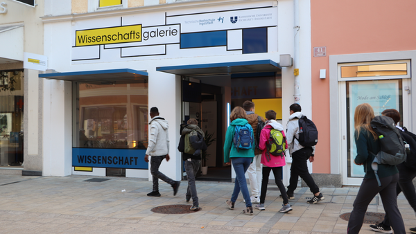 Menschen gehen vor einem Schaufenster